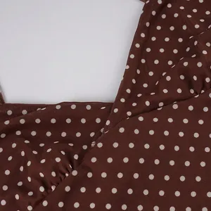 Detail view of brown polka dot dress neckline showing delicate mesh fabric texture