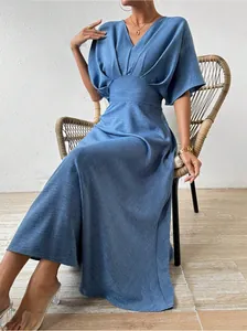 Elegant blue V-neck high-waist maxi dress for summer, featured in a woven chair