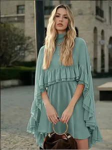 Gedetailleerde weergave van een groen chiffon tweedelig jurkje met ruches op een model.