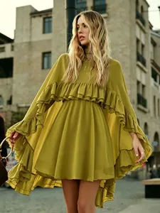 Detail van mosterdgele chiffon jurk met elegante gelaagde ruches en cape-mouwen