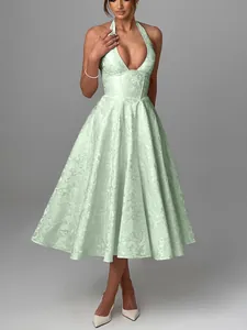 Detail showing the elegant jacquard pattern on a mint green halter neck evening midi dress
