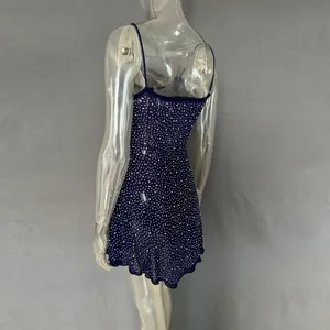 Macro detail of a navy blue sheer mini dress featuring all-over rhinestones on a mannequin