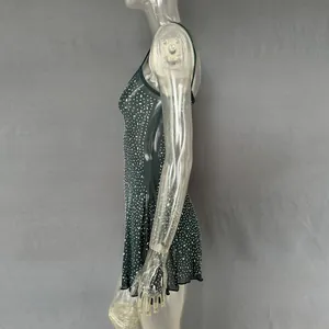 Side profile of a sheer dark green party mini dress with sparkling hot-fix rhinestones