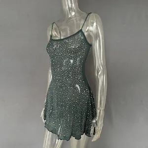 Detail view of a dark green party mini dress featuring sparkling rhinestones and mesh fabric