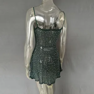 Back view of sheer dark green mini dress with rhinestone details on a mannequin.