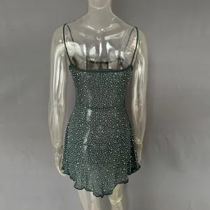 Back view detail of a dark green sheer mini dress decorated with shimmering rhinestones.