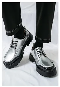Détail de chaussures habillées argentées pour hommes avec semelles compensées noires