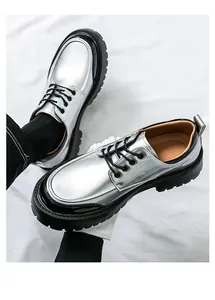 Gros plan détaillé de chaussures habillées métallisées argentées avec semelles noires.
