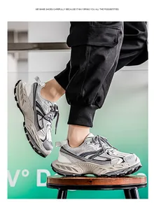Close-up view of grey breathable men's chunky sneakers with thick platform soles on model