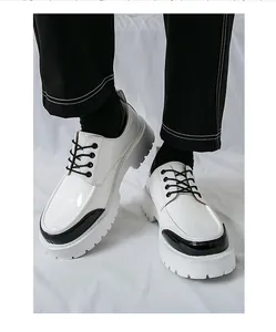 Gros plan de chaussures de ville en cuir verni blanc pour homme avec accents noirs.