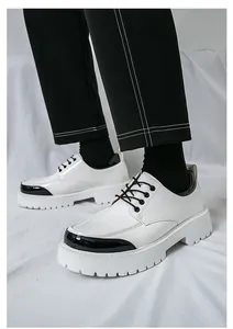 Détail de chaussures habillées à plateforme blanches pour hommes avec bout noir élégant