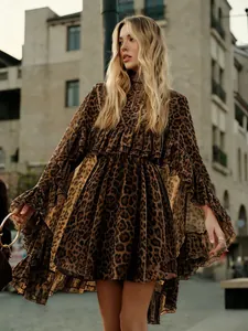 Elegante chiffon jurk met luipaardprint en stijlvolle ruches in een buitenomgeving.