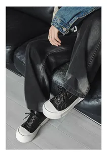 Close-up detail of stylish black and white platform sneakers with wide-leg pants