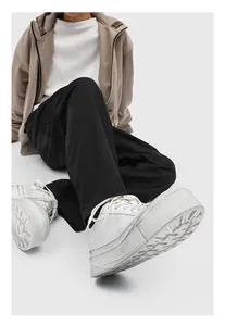 Close-up of men's white platform sneakers showing thick sole and trendy design