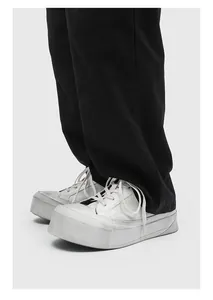 Detailed view of white men's chunky platform sneakers with minimalist leather design