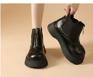 Detail shot of black platform Chelsea boots featuring a front zipper and thick soles.