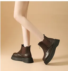 Close-up detail of women's thick-soled Chelsea boots in dark brown worn by a model.