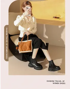 Woman wearing chunky black Chelsea boots in a desert-themed indoor lifestyle setting.