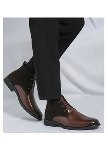 Vista laterale di stivaletti chukka da uomo in pelle marrone indossati con pantaloni neri