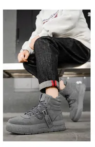 Primo piano di sneakers alte grigie da uomo con suole spesse e dettagli stringati.