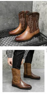 Detail of vintage brown leather cowboy boots with white embroidery and side zipper
