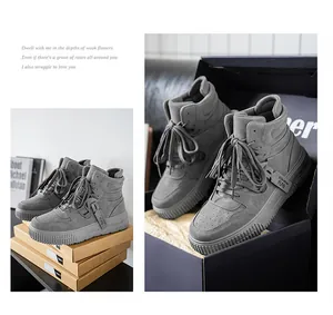 Dettaglio sneaker alte grigie in una scatola da scarpe nera, finitura effetto pelle.