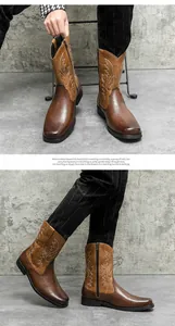 Detailed view of men's vintage brown cowboy boots with intricate white embroidery