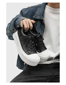 Detailed shot of men's low-top black and white platform sneakers with chunky soles