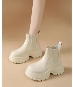 Close-up of beige chunky platform Chelsea boots featuring elastic side panels