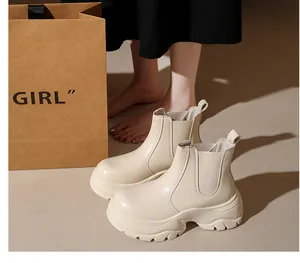 Close-up of beige platform Chelsea boots with thick lug soles and elastic side panels