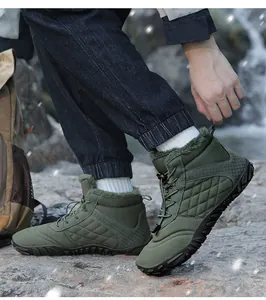 Detail van legergroene, met bont gevoerde snowboots voor heren in een buitenomgeving