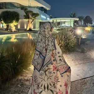Rear view of a floral printed long coat and matching headscarf in a luxury night garden