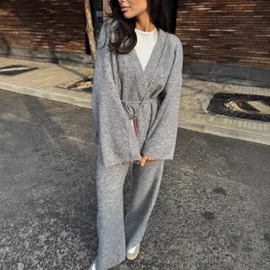 Chic women's grey ribbed knit two-piece set featuring V-neck tie sweater and wide-leg trousers.