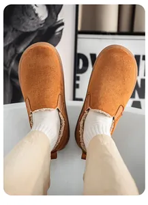 Close-up detail of men's brown suede-like fleece-lined slip-on winter boots being worn