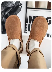 Close-up of men's brown suede slip-on snow boots with warm white fleece lining and soft sole