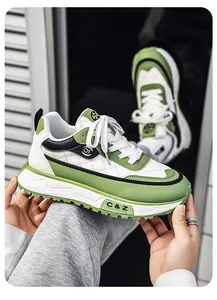 Vista detallada de zapatillas dad de suela gruesa en verde y blanco sostenidas con la mano