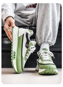 Detalle de las zapatillas de hombre a la moda con suela gruesa en color verde y blanco