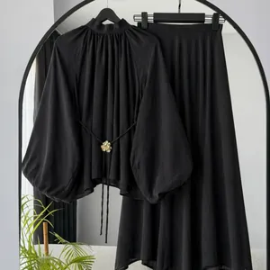 Elegantes schwarzes zweiteiliges Set mit Langarm-Oberteil und langem Rock Detail.