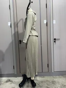 Vista lateral de un elegante conjunto de chaqueta con botones y falda midi plisada
