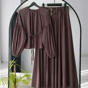 Detailed view of women's autumn dark mauve long-sleeve tie-waist top and A-line skirt set
