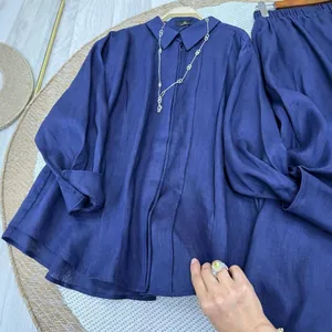 Detail view of navy blue linen-blend long-sleeved shirt and skirt set showing rich fabric texture