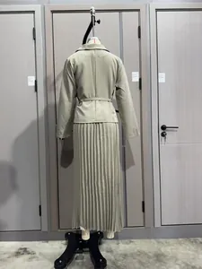 Vista posterior de un conjunto profesional de chaqueta y falda plisada verde claro en un maniquí