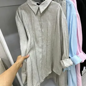 Detailed view of the pleated front design on a beige linen-texture long-sleeve shirt
