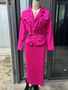Elegante conjunto rosa vibrante de blazer con cinturón y falda larga plisada