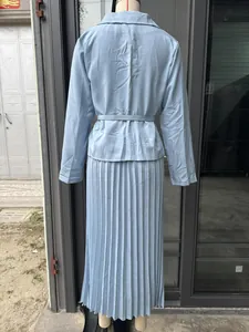 Vista trasera detallada de un conjunto de blazer azul claro y falda plisada en maniquí