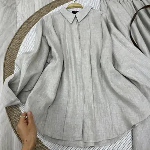 Detailed texture view of women's linen long-sleeve shirt and matching skirt set in light grey