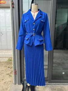 Vista frontal del blazer azul real y el conjunto de falda larga plisada en maniquí