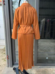 Vista posterior detallada de un elegante conjunto de blazer y falda plisada naranja en maniquí