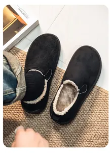 Close-up detail of black suede winter slippers showing the warm and cozy faux fur lining.