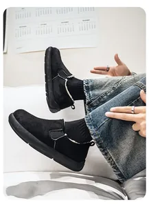 Close-up detail view of black fleece-lined slip-on snow boots worn with blue jeans